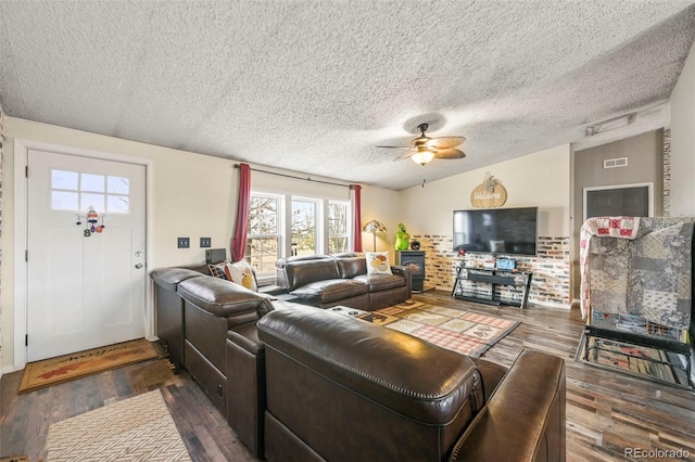 living room with dark wood-type flooring, ceiling fan, a textured ceiling, and lofted ceiling