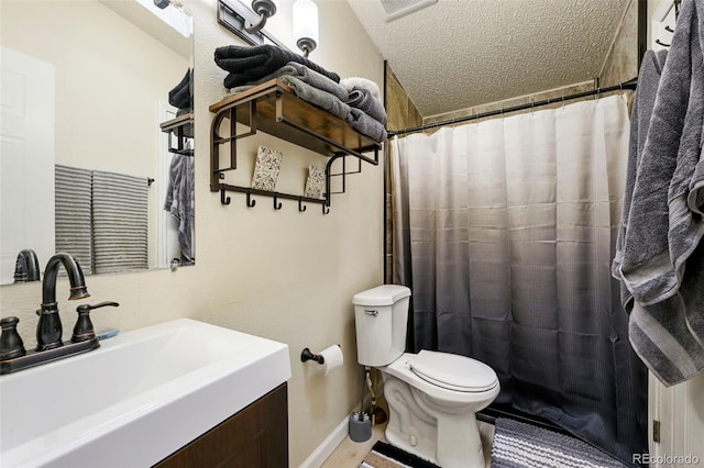 bathroom featuring vanity, toilet, a textured ceiling, and walk in shower