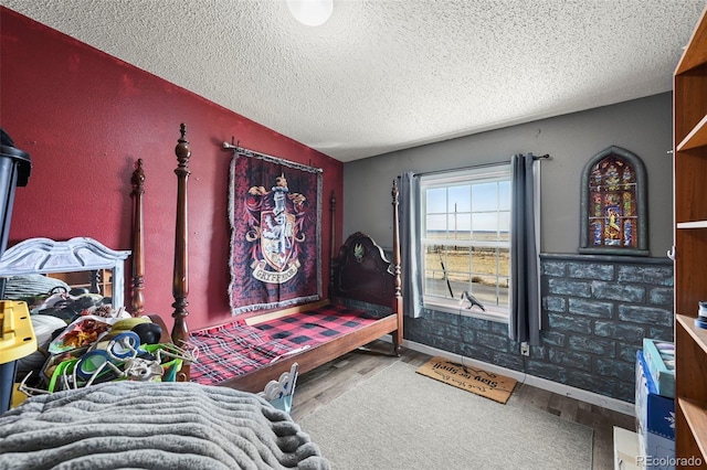 bedroom with a textured ceiling and hardwood / wood-style flooring