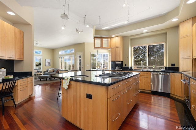 kitchen with dark wood-style flooring, recessed lighting, a breakfast bar area, and appliances with stainless steel finishes