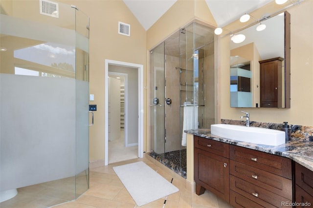 full bath with vaulted ceiling, vanity, visible vents, and a shower stall