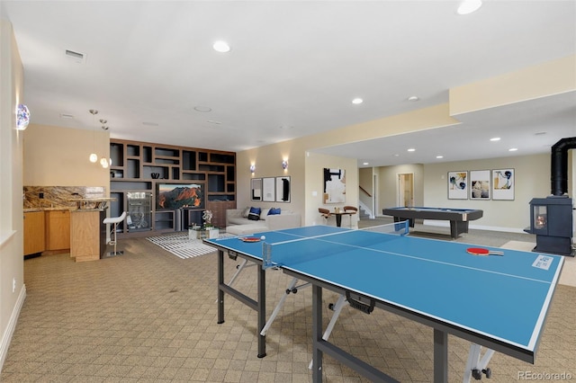 rec room with a wood stove, light carpet, and recessed lighting