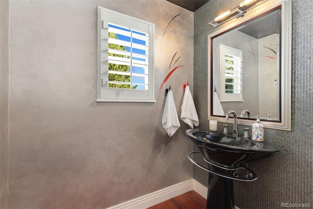 bathroom with plenty of natural light, baseboards, wood finished floors, and a sink