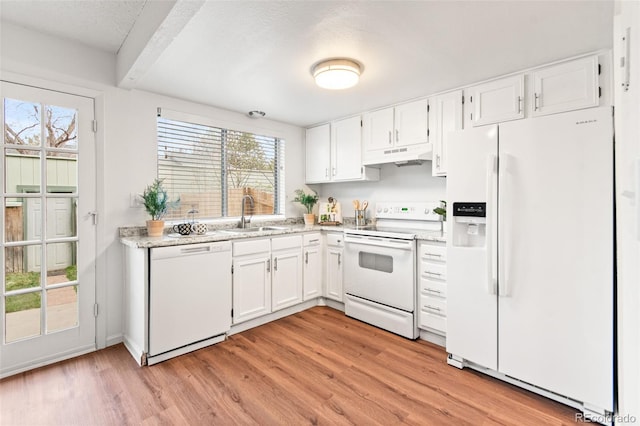 kitchen featuring white appliances, under cabinet range hood, a sink, light wood-style flooring, and a textured ceiling