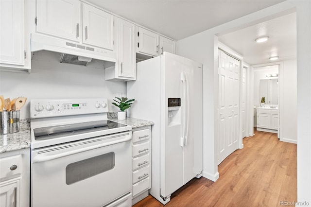 kitchen featuring white appliances, under cabinet range hood, light wood-style flooring, white cabinetry, and light stone countertops
