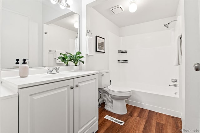 bathroom featuring wood finished floors, toilet, shower / tub combination, and vanity