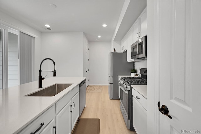 4612 S Wenatchee St Unit A, Aurora, CO 80015 - kitchen featuring appliances with stainless steel finishes, recessed lighting, white cabinetry, light wood finished floors, and light countertops