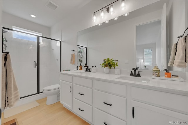 4612 S Wenatchee St Unit A, Aurora, CO 80015 - full bathroom featuring double vanity, healthy amount of natural light, a stall shower, and wood finished floors