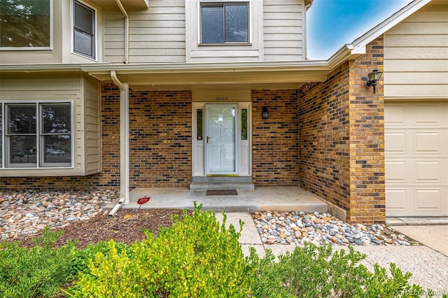 6005 S Vivian St, Littleton, CO 80127 - view of exterior entry with brick siding and a garage