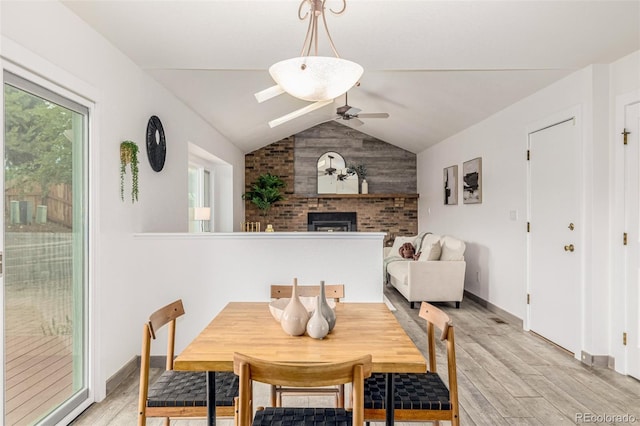 6005 S Vivian St, Littleton, CO 80127 - dining room with ceiling fan, light wood-type flooring, a fireplace, lofted ceiling, and a skylight