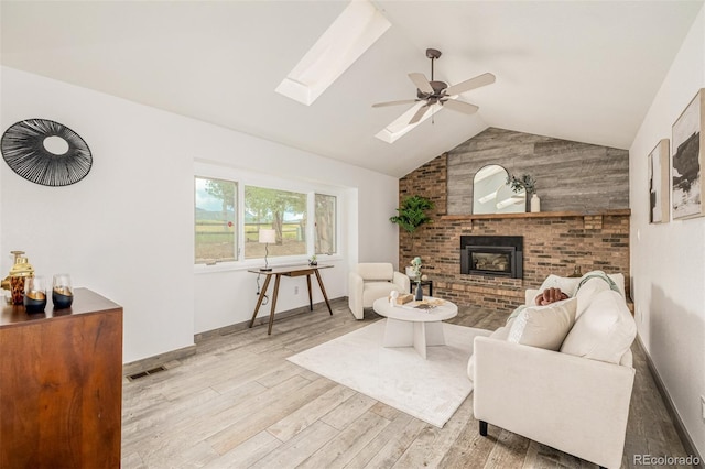6005 S Vivian St, Littleton, CO 80127 - living area with wood finished floors, vaulted ceiling, a ceiling fan, a brick fireplace, and a skylight