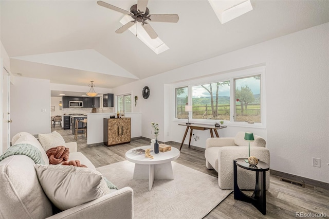 6005 S Vivian St, Littleton, CO 80127 - living area featuring vaulted ceiling, a skylight, light wood finished floors, and ceiling fan