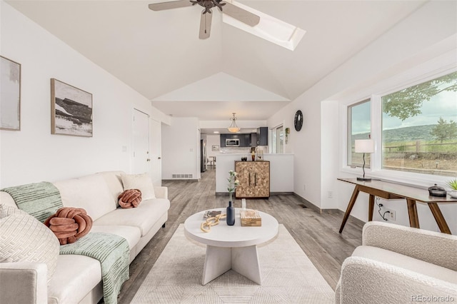 6005 S Vivian St, Littleton, CO 80127 - living area with light wood-style flooring, vaulted ceiling, a ceiling fan, and a skylight