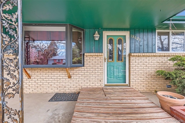 view of exterior entry featuring brick siding