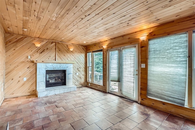 unfurnished living room featuring wooden ceiling, wood walls, and a fireplace