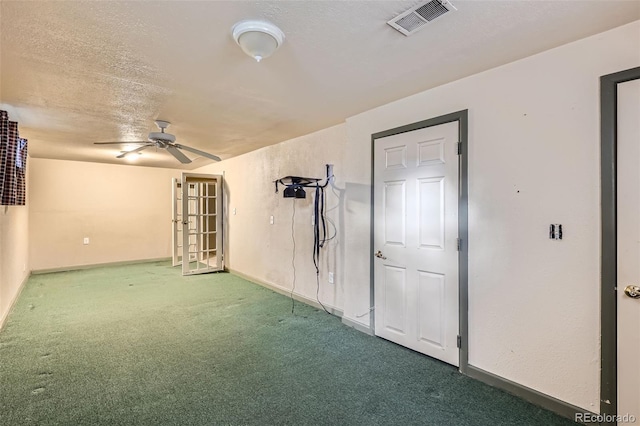 carpeted spare room with visible vents, a ceiling fan, and baseboards