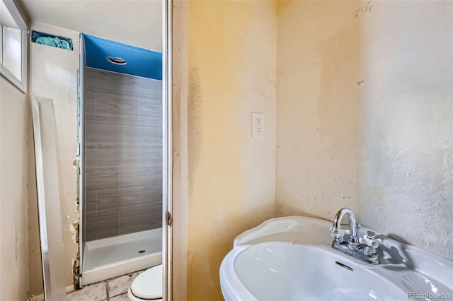 bathroom featuring tile patterned flooring, a sink, and a stall shower