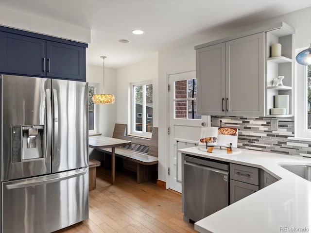 2535 Leyden St, Denver, CO 80207 - kitchen with stainless steel appliances, open shelves, tasteful backsplash, light countertops, and light wood finished floors