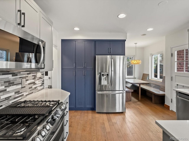 2535 Leyden St, Denver, CO 80207 - kitchen featuring appliances with stainless steel finishes, backsplash, light countertops, light wood-type flooring, and recessed lighting