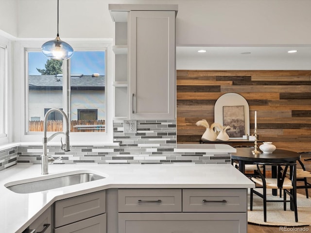 2535 Leyden St, Denver, CO 80207 - kitchen with gray cabinets, a sink, backsplash, light countertops, and hanging light fixtures