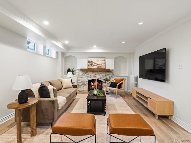 2535 Leyden St, Denver, CO 80207 - living area featuring light wood-style flooring, arched walkways, ornamental molding, recessed lighting, and a stone fireplace