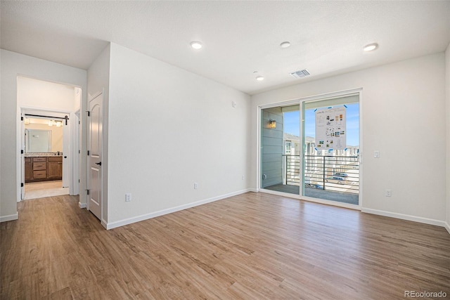 unfurnished room with recessed lighting, visible vents, baseboards, and wood finished floors