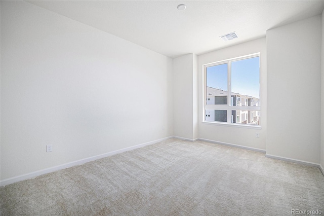 empty room with baseboards, visible vents, and carpet flooring