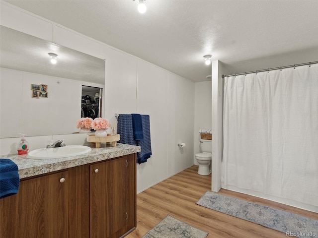 69501 E 72nd Ave, Byers, CO 80103 - full bath with vanity, wood finished floors, and a shower with shower curtain