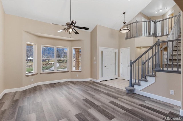 foyer entrance featuring stairs, baseboards, and wood finished floors