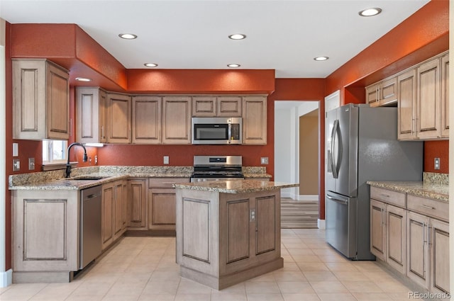 kitchen featuring stainless steel appliances, a center island, a sink, and light stone countertops