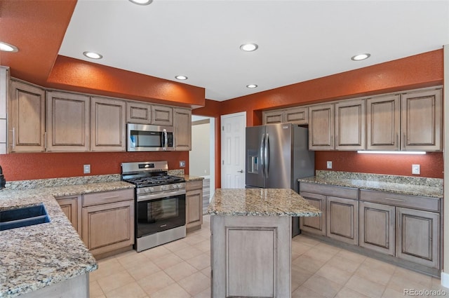 kitchen featuring light stone countertops, a center island, stainless steel appliances, and recessed lighting