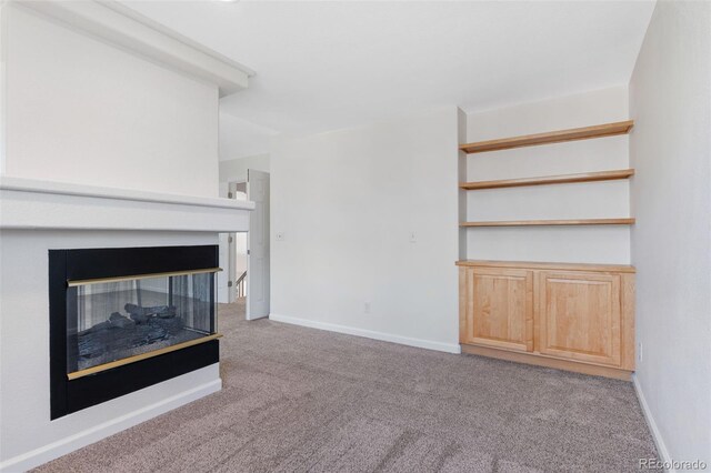 unfurnished living room with baseboards, carpet flooring, and a multi sided fireplace