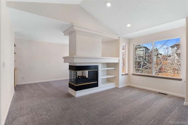 unfurnished living room with baseboards, visible vents, vaulted ceiling, carpet flooring, and a multi sided fireplace