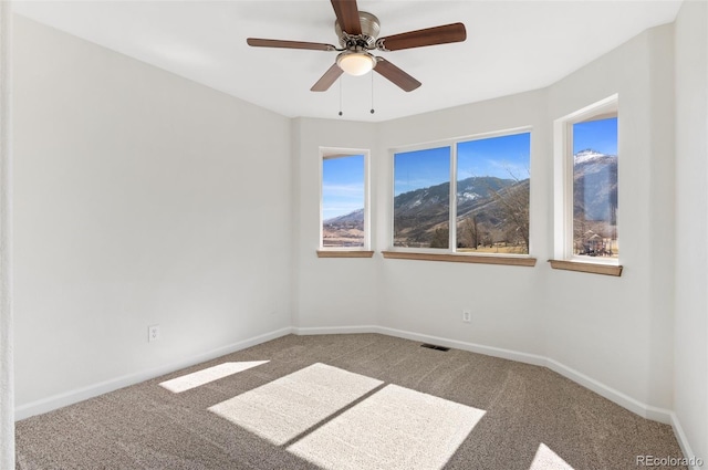 unfurnished room with carpet, visible vents, ceiling fan, and baseboards