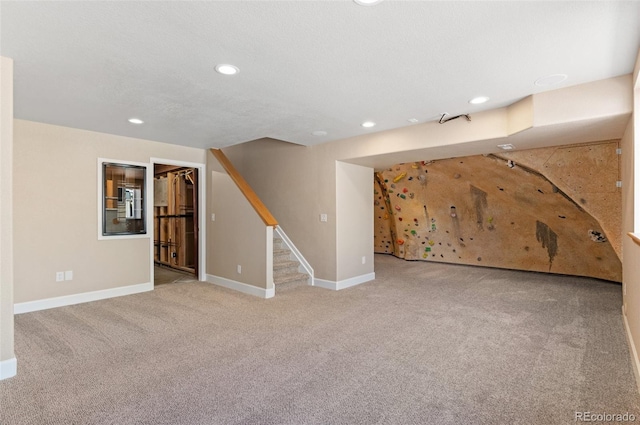 finished basement with stairs, carpet, baseboards, and recessed lighting