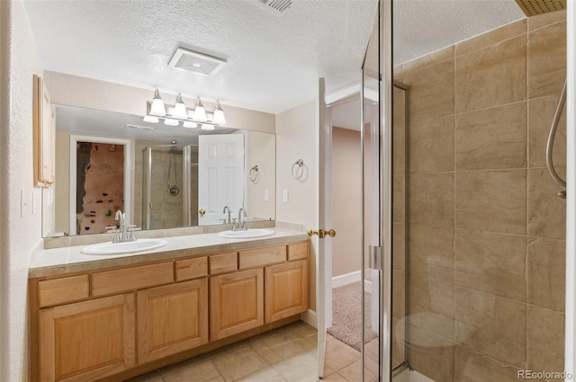 bathroom with a textured ceiling, a sink, and a shower stall