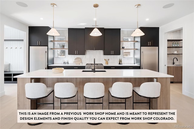 kitchen featuring decorative light fixtures and a center island with sink