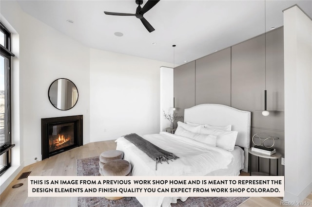 bedroom featuring light wood-type flooring, multiple windows, and ceiling fan