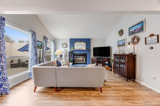 1236 Sequerra St, Broomfield, CO 80020 - living area featuring vaulted ceiling, light wood finished floors, and a brick fireplace