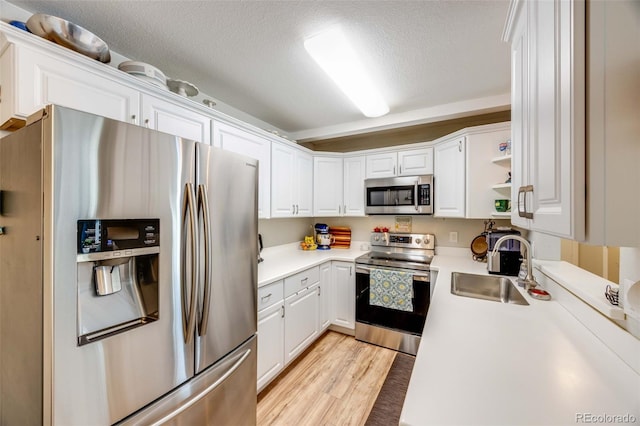 1236 Sequerra St, Broomfield, CO 80020 - kitchen featuring appliances with stainless steel finishes, white cabinets, light countertops, and a textured ceiling