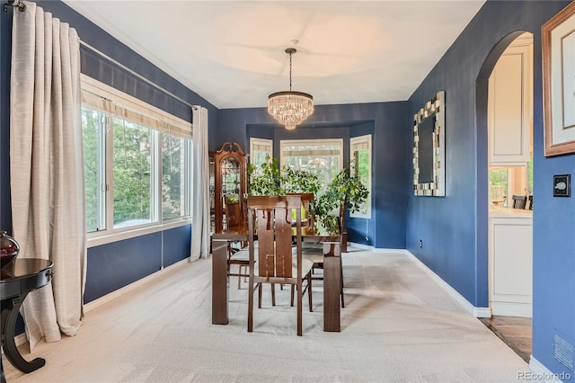 carpeted dining space featuring a chandelier