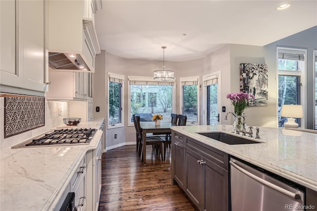 kitchen with appliances with stainless steel finishes, sink, decorative light fixtures, plenty of natural light, and decorative backsplash