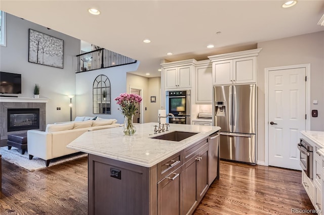 kitchen with sink, stainless steel appliances, white cabinetry, and dark hardwood / wood-style floors