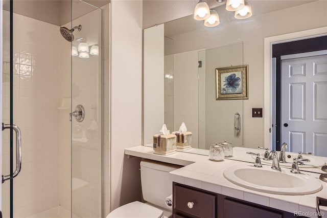 bathroom with toilet, a shower with shower door, and vanity