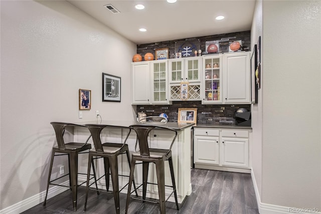 bar featuring decorative backsplash, white cabinets, and dark hardwood / wood-style floors