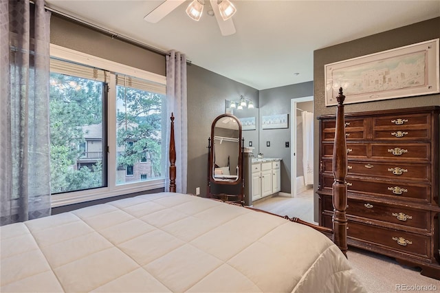 bedroom featuring ceiling fan, multiple windows, and ensuite bathroom