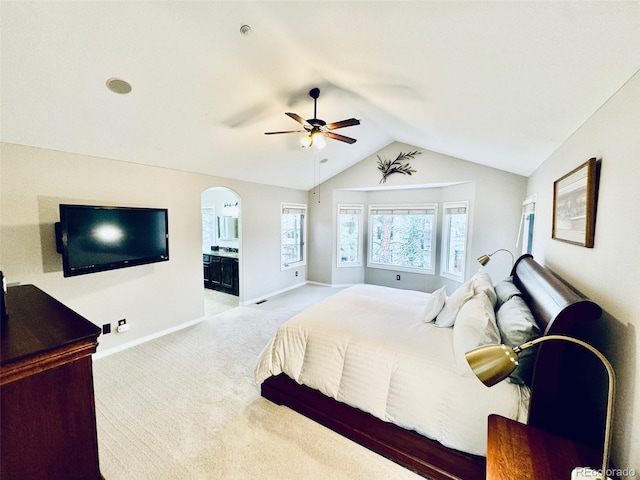 carpeted bedroom featuring connected bathroom, vaulted ceiling, and ceiling fan