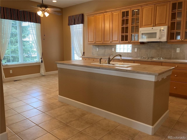 kitchen with white appliances, ceiling fan, plenty of natural light, and sink