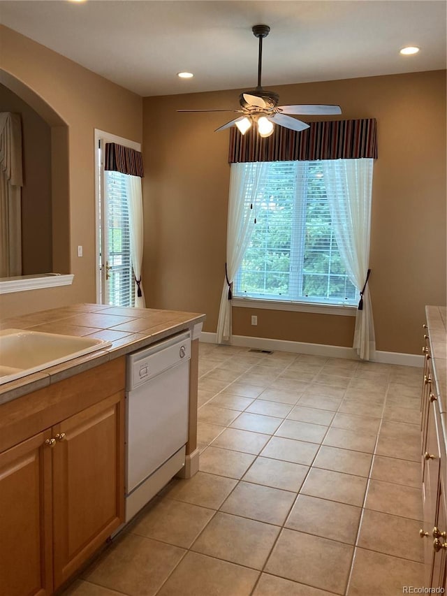 kitchen featuring light tile patterned floors, ceiling fan, dishwasher, and a healthy amount of sunlight