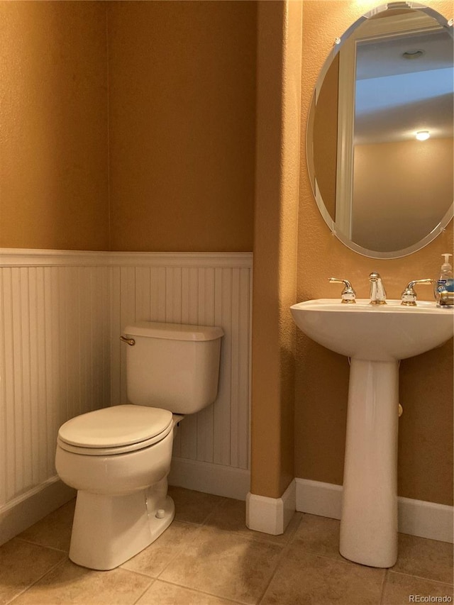 bathroom featuring tile patterned flooring, toilet, and sink